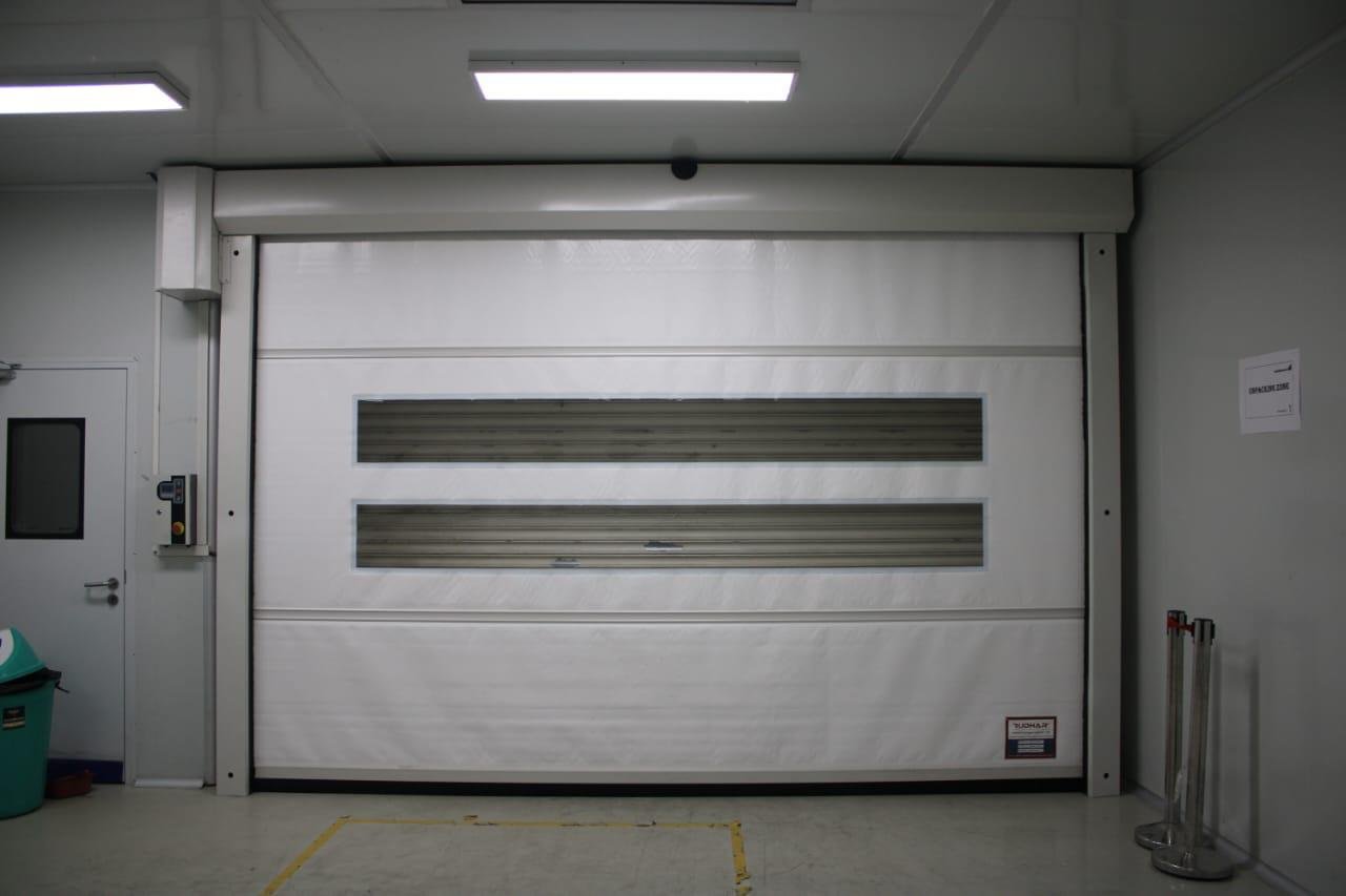 White high-speed roll-up door installed in an industrial clean area